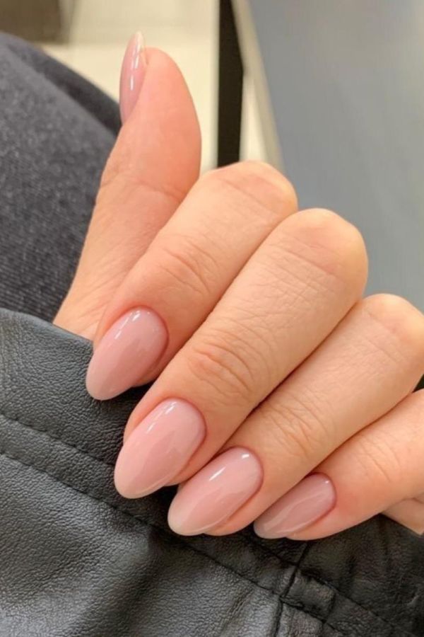 Natural nude micro French tip nails typing on laptop, professional almond nail designs