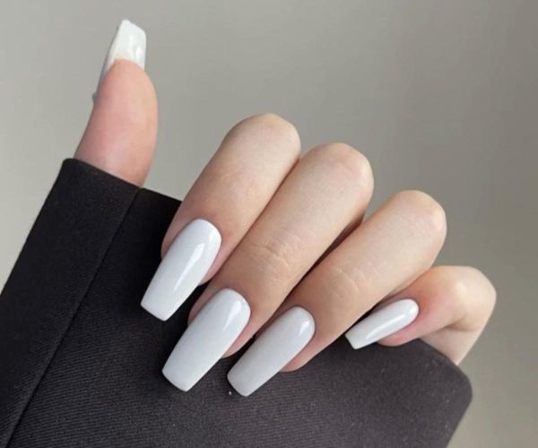 Short square milky white glossy nails in soft sunlight, professional gel nail designs