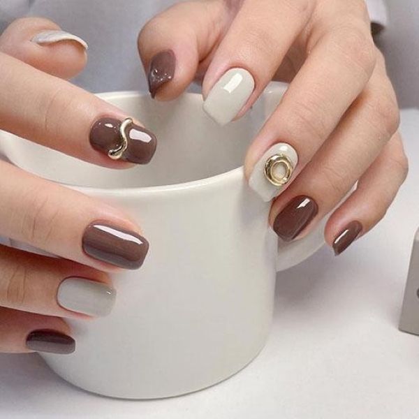 Minimal taupe manicure holding coffee cup gold lines
