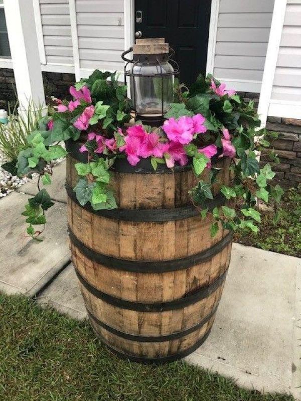 Front lawn corner with whiskey barrel vegetable planters, tomatoes and rosemary, rustic brick backdrop, cloudy daylight for front lawn vegetable garden ideas