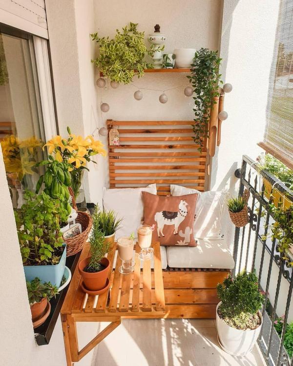 Cozy cottagecore balcony vegetable garden with white planters, layered textiles, string lights, and fresh herbs on a narrow apartment balcony