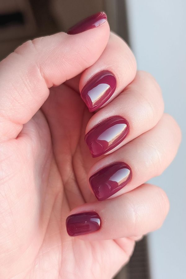 Elegant red nail designs for wedding looks with glossy deep burgundy nails and a minimalist finish