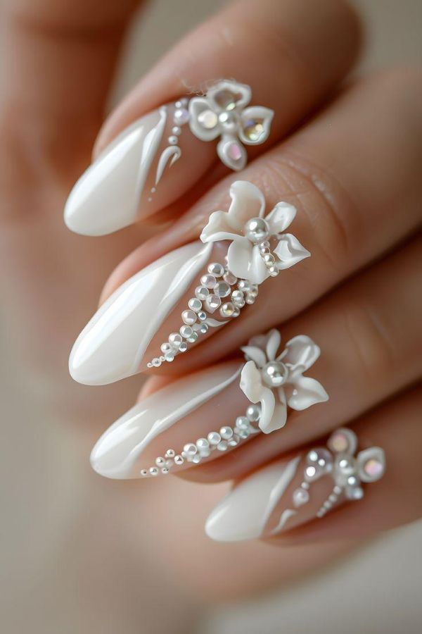 White Orchid Wedding Nails with delicate 3D floral details, pearl accents, and glossy white almond nails
