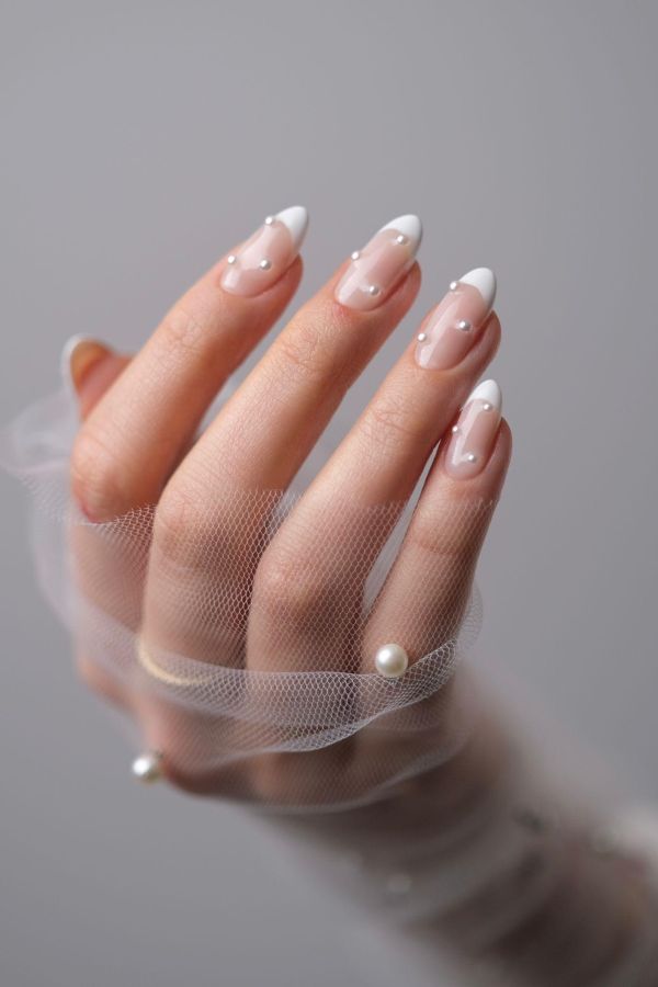 Elegant nail designs for weddings with white French tips and pearl accents on almond nails