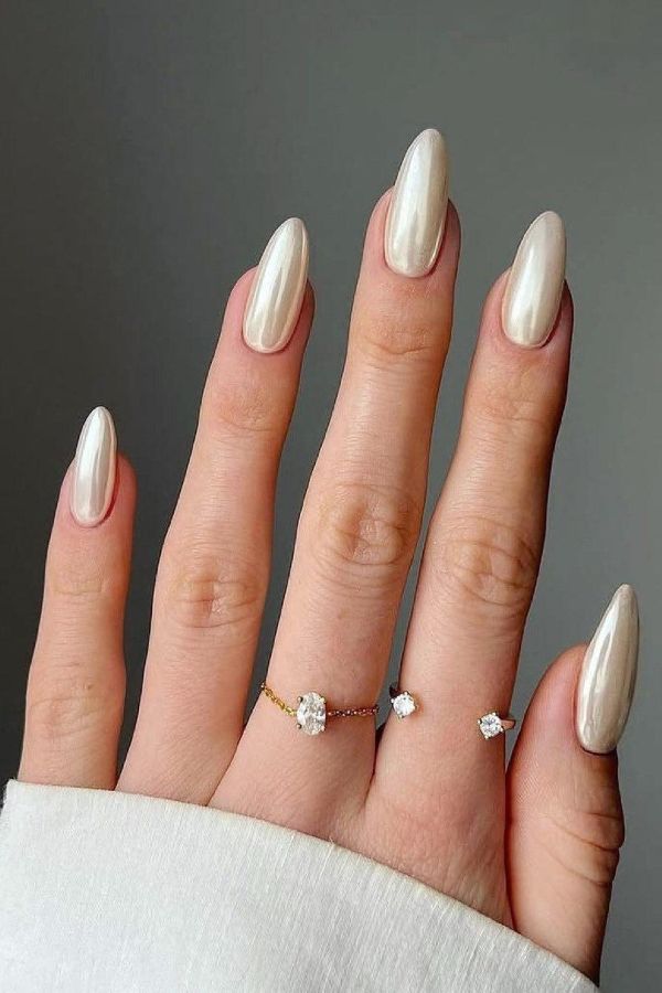 Pearl chrome bridal nails with glossy ivory metallic finish on almond nails