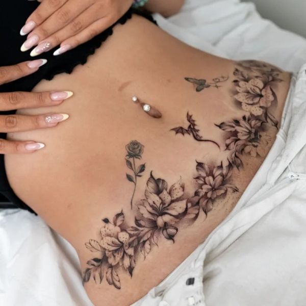 Wrap around flower tattoo waist with soft black and grey floral shading