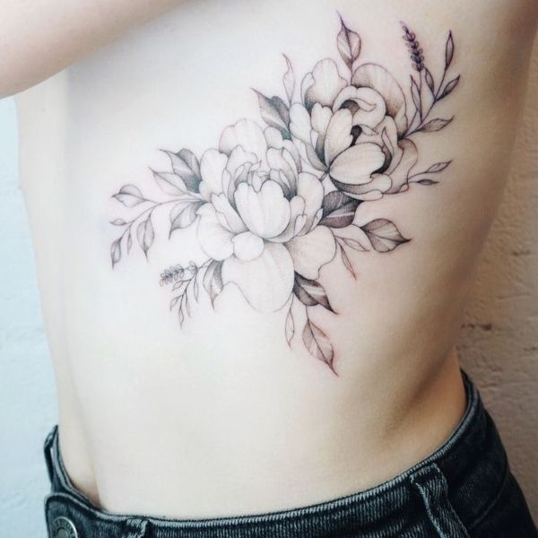 Black and grey peony waist tattoo with soft floral shading