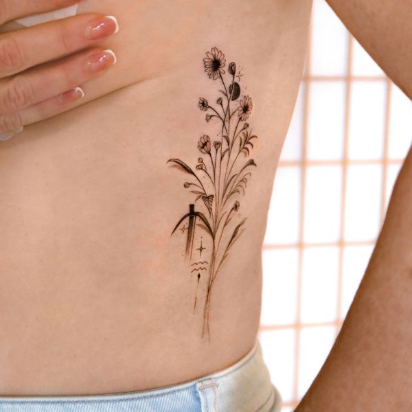 Wildflower waist tattoo with fine line botanical details and soft flow
