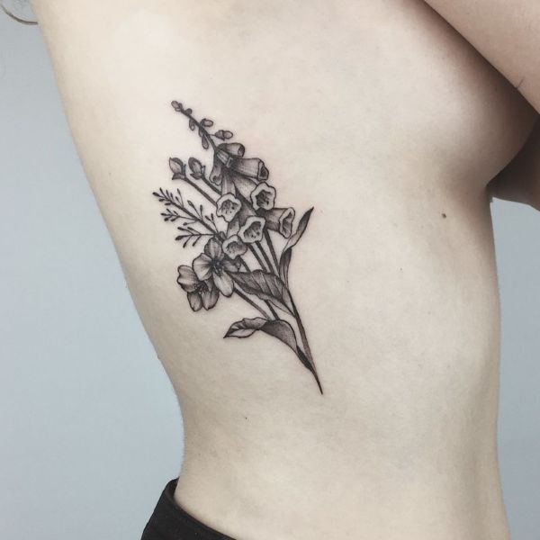 Black and grey wildflower waist tattoo with soft botanical shading