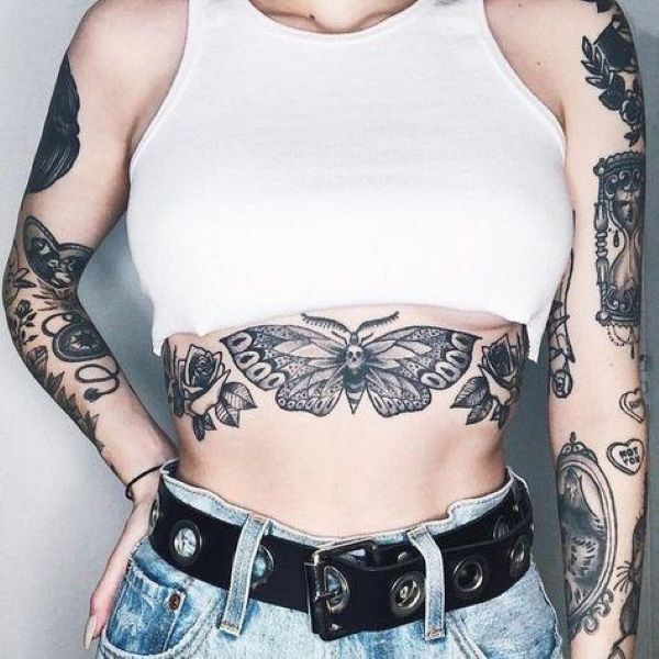Rib-Hugging Moth Tattoo stretching across the underboob with symmetrical wings and floral side elements