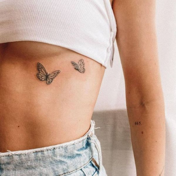 Small moth tattoo on the underboob with minimal fine line wings and delicate detail