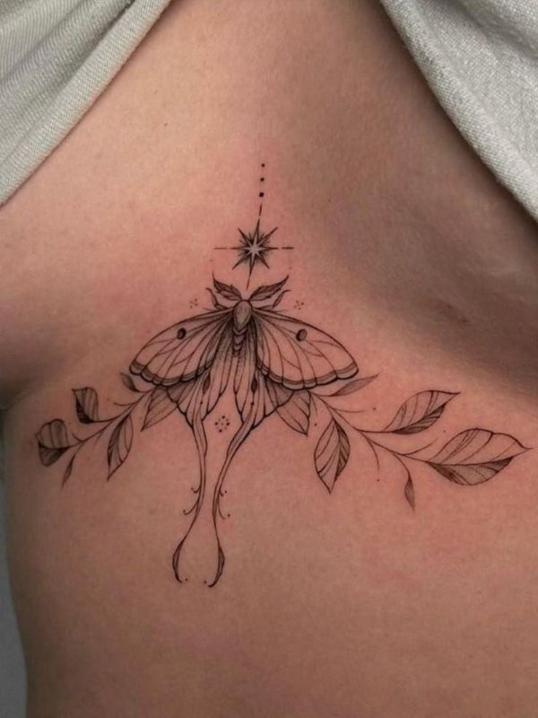 Luna moth underboob tattoo with fine line wings, star detail, and flowing leaves along the chest