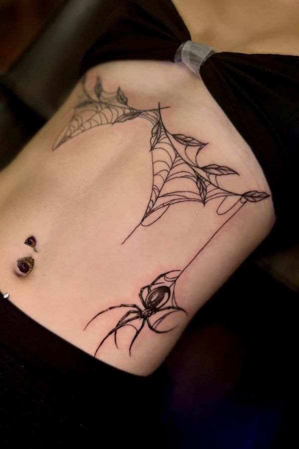 Ornamental spiderweb sternum tattoo with fine line leaves and spider detail - teeartonline.com